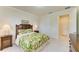 Bright bedroom with tropical-themed bedding, side tables, and a glimpse of a closet at 6756 Chester Trl, Lakewood Ranch, FL 34202