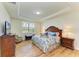 Cozy bedroom features a tray ceiling, a window with shutters, and wood floors at 6756 Chester Trl, Lakewood Ranch, FL 34202
