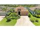 Charming home with tile roof, brick driveway, and lush landscaping near a tranquil lake at 6756 Chester Trl, Lakewood Ranch, FL 34202