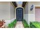 A secure front door is nestled in a stucco wall and decorative wall sconce at 6756 Chester Trl, Lakewood Ranch, FL 34202