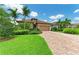 Beautiful single-story home featuring lush landscaping, a brick driveway, and a well-maintained lawn at 6756 Chester Trl, Lakewood Ranch, FL 34202