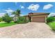 Well-maintained home featuring mature landscaping, a brick driveway, and neutral color palette at 6756 Chester Trl, Lakewood Ranch, FL 34202