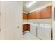 Bright laundry room featuring a washer and dryer set with brown cabinets at 6756 Chester Trl, Lakewood Ranch, FL 34202