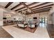 Open and airy lounge with coffered ceilings, stylish furniture, fireplace, and dining area at 6756 Chester Trl, Lakewood Ranch, FL 34202