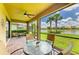 Screened patio with brick floor, ceiling fan, table and chairs overlooking a lake and green space at 6756 Chester Trl, Lakewood Ranch, FL 34202