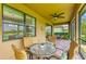 Screened patio with brick floor, ceiling fan, table and chairs overlooking a lake and green space at 6756 Chester Trl, Lakewood Ranch, FL 34202