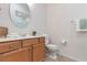 Bathroom vanity featuring a round mirror, neutral walls, tile floors and a toilet at 7314 Hamilton Rd, Bradenton, FL 34209