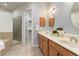 Bathroom featuring double sinks, wood cabinets, tiled floors, walk-in shower and separate tub at 7314 Hamilton Rd, Bradenton, FL 34209