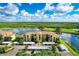 Stunning aerial view of condo complex overlooking a serene lake and lush golf course under a partly cloudy sky at 7911 Grand Estuary Trl # 102, Bradenton, FL 34212