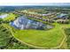 Overhead view of community and golf course featuring multiple residences surrounding a serene lake reflecting the sky at 7911 Grand Estuary Trl # 102, Bradenton, FL 34212