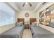 Cozy bedroom with twin beds, tasteful decor, and a ceiling fan providing a comfortable and stylish space at 7911 Grand Estuary Trl # 102, Bradenton, FL 34212