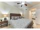 Bedroom featuring a ceiling fan, wicker headboard, and an ensuite bathroom, offering convenience and style at 7911 Grand Estuary Trl # 102, Bradenton, FL 34212