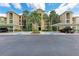 Exterior of a condominium building showcasing lush landscaping and ample parking at 7911 Grand Estuary Trl # 102, Bradenton, FL 34212