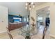 Open-concept dining area adjacent to a comfortable living room, features a round glass-top table and four chairs at 7911 Grand Estuary Trl # 102, Bradenton, FL 34212
