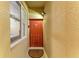 Close up of front door with tan textured walls, transom window, and decorative sun patterned welcome mat at 7911 Grand Estuary Trl # 102, Bradenton, FL 34212