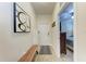 Inviting hallway with a stylish bench, modern artwork, and a glimpse into a cozy bedroom, leading to front door at 7911 Grand Estuary Trl # 102, Bradenton, FL 34212