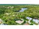 Aerial view of a home near a pond surrounded by lush greenery at 8047 Desoto Woods Dr, Sarasota, FL 34243