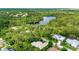 Aerial view of houses near lake surrounded by lush greenery at 8047 Desoto Woods Dr, Sarasota, FL 34243