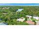 Breathtaking aerial view of home surrounded by lush greenery, lake, and neighborhood at 8047 Desoto Woods Dr, Sarasota, FL 34243