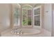 Garden tub with jetted tub, tile surround and plantation shutters at 8047 Desoto Woods Dr, Sarasota, FL 34243