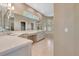 Bright primary bathroom featuring dual sinks, quartz counters, large mirror, and soaking tub with natural light at 8047 Desoto Woods Dr, Sarasota, FL 34243