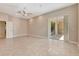 Open bedroom with tile flooring, ceiling fan, and slider doors leading to the outdoor living space at 8047 Desoto Woods Dr, Sarasota, FL 34243