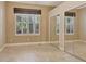 Bedroom featuring tile floors, closet with mirror doors, and a window with wood blinds at 8047 Desoto Woods Dr, Sarasota, FL 34243