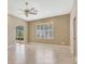 Bright bedroom with tile flooring, ceiling fan, window with plantation shutters, and adjacent bathroom at 8047 Desoto Woods Dr, Sarasota, FL 34243