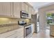 Stylish kitchen featuring stainless steel appliances and light-colored granite countertops at 8047 Desoto Woods Dr, Sarasota, FL 34243