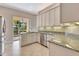 Bright kitchen with white cabinets, granite countertops, stainless appliances, and sliding doors to the outside at 8047 Desoto Woods Dr, Sarasota, FL 34243