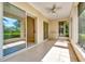 Covered lanai with tile floors, a ceiling fan, wet bar, and view of the mature landscaping at 8047 Desoto Woods Dr, Sarasota, FL 34243