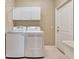 Well-lit laundry room with washer, dryer, upper cabinets, and utility sink at 8047 Desoto Woods Dr, Sarasota, FL 34243
