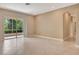 Open living room features sliding glass doors to patio and neutral walls and tiled flooring at 8047 Desoto Woods Dr, Sarasota, FL 34243