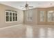Expansive living room with tile floors, large windows, and a ceiling fan at 8047 Desoto Woods Dr, Sarasota, FL 34243