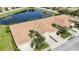 Aerial view featuring residences with tile roofs, manicured lawns, and beautiful landscaping near a serene pond at 8224 Simpson Falls Ct # 8224, Sarasota, FL 34243