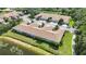 Aerial view of residences with tile roofs, manicured lawns, and easy access to the nearby scenic pond at 8224 Simpson Falls Ct # 8224, Sarasota, FL 34243