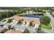 Aerial view of residences featuring tile roofs, manicured lawns, and a serene pond in a lush neighborhood at 8224 Simpson Falls Ct # 8224, Sarasota, FL 34243