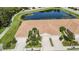 Overhead view of townhomes featuring tile roofs, manicured landscaping, and close proximity to a scenic pond at 8224 Simpson Falls Ct # 8224, Sarasota, FL 34243