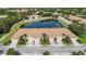 Aerial view of townhomes shows private drives, garages, lake and landscaping at 8224 Simpson Falls Ct # 8224, Sarasota, FL 34243