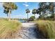 Scenic beach access with colorful Adirondack chairs overlooking the water, surrounded by natural grasses at 8224 Simpson Falls Ct # 8224, Sarasota, FL 34243