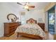 Comfortable bedroom featuring hardwood floors, ceiling fan, dresser, and sliding glass doors to a patio at 8224 Simpson Falls Ct # 8224, Sarasota, FL 34243