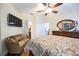 Spacious bedroom with hardwood floors, ceiling fan, wicker couch, dresser, and access to the ensuite bathroom at 8224 Simpson Falls Ct # 8224, Sarasota, FL 34243