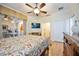 Well-lit bedroom with hardwood floors, ceiling fan, dresser, television, and sliding glass doors to a patio at 8224 Simpson Falls Ct # 8224, Sarasota, FL 34243