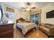 Cozy bedroom with hardwood floors, ceiling fan, dresser, wicker couch, and sliding glass doors to a patio at 8224 Simpson Falls Ct # 8224, Sarasota, FL 34243