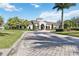 A beautiful single-story clubhouse with a well-manicured lawn, palm trees and inviting entrance at 8224 Simpson Falls Ct # 8224, Sarasota, FL 34243