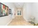 Hallway with neutral walls, tiled floors, artwork, and door to the exercise area at 8224 Simpson Falls Ct # 8224, Sarasota, FL 34243