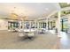 Spacious room with tables, chairs, and hanging chandeliers in the Lakeridge Falls Clubhouse at 8224 Simpson Falls Ct # 8224, Sarasota, FL 34243