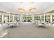 Spacious room with tables, chairs, and hanging chandeliers in the Lakeridge Falls Clubhouse at 8224 Simpson Falls Ct # 8224, Sarasota, FL 34243