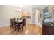 Open concept dining room flows into the kitchen area, featuring a modern light fixture and wood flooring at 8224 Simpson Falls Ct # 8224, Sarasota, FL 34243
