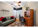 Well-lit home office with hardwood floors, ceiling fan, stylish rug, couch, and a built-in desk with shelving at 8224 Simpson Falls Ct # 8224, Sarasota, FL 34243
